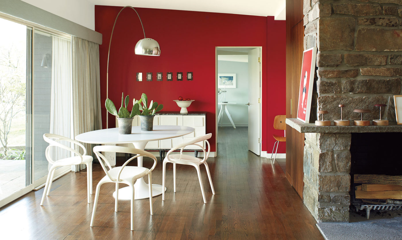 Dining area with an accent wall in Benjamin Moore's 2018 color of the year, a deep red, and a white round table