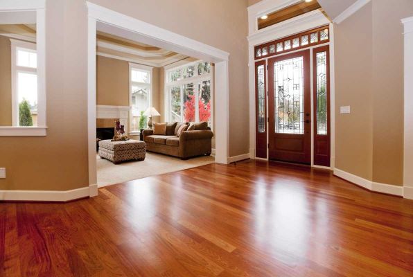 Entry with a glossy reddish hardwood floor, beige walls, white trim and a wood front door with glass panels