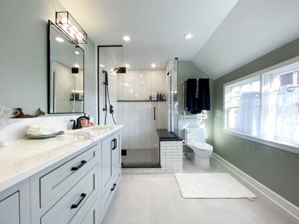Bathroom with a light gray vanity, sage green walls, a light gray floor and a glass walk-in shower