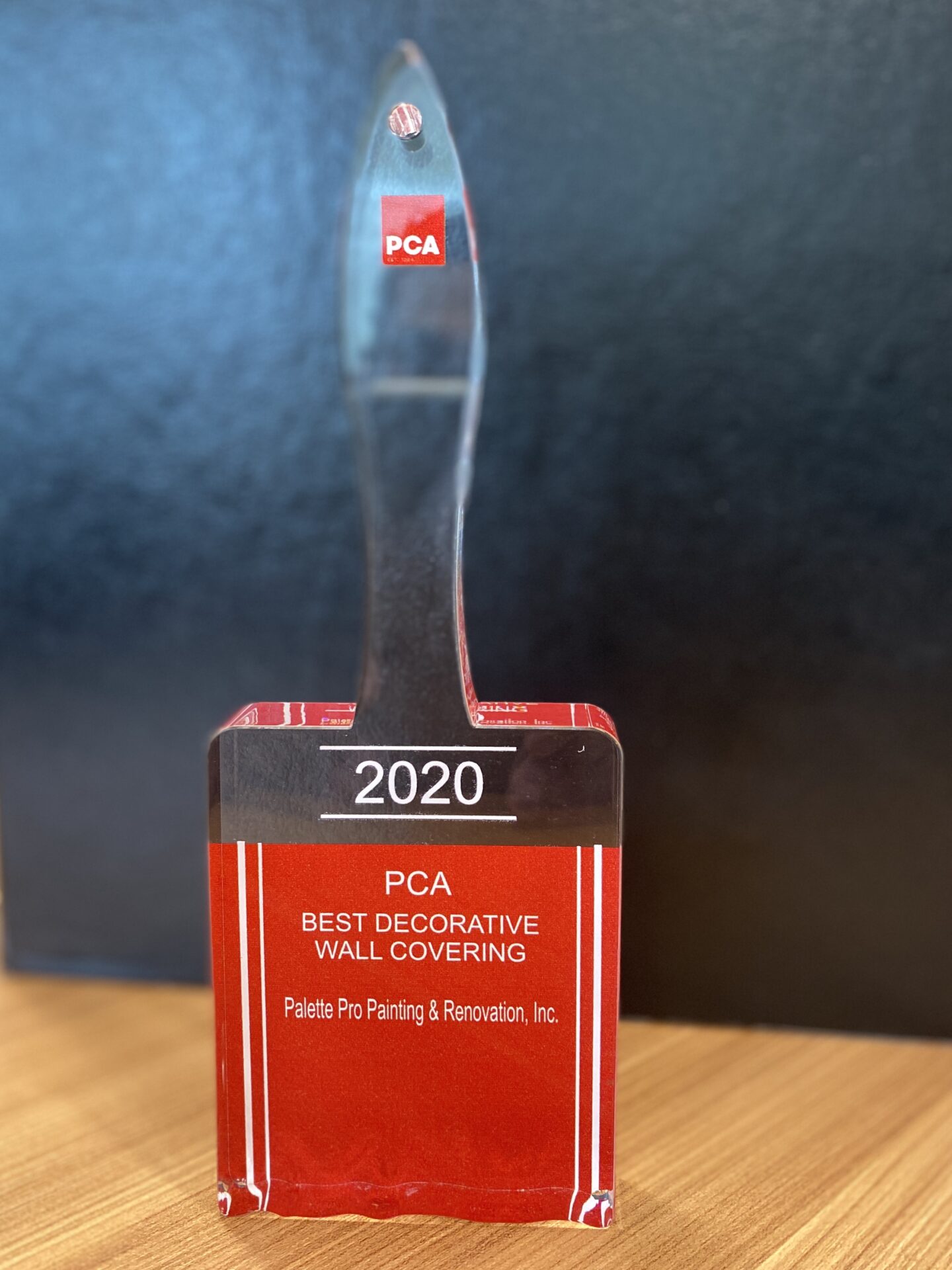 2020 PCA Best Decorative Wall Covering award for Palette Pro, shaped like a clear acrylic paintbrush on a red base