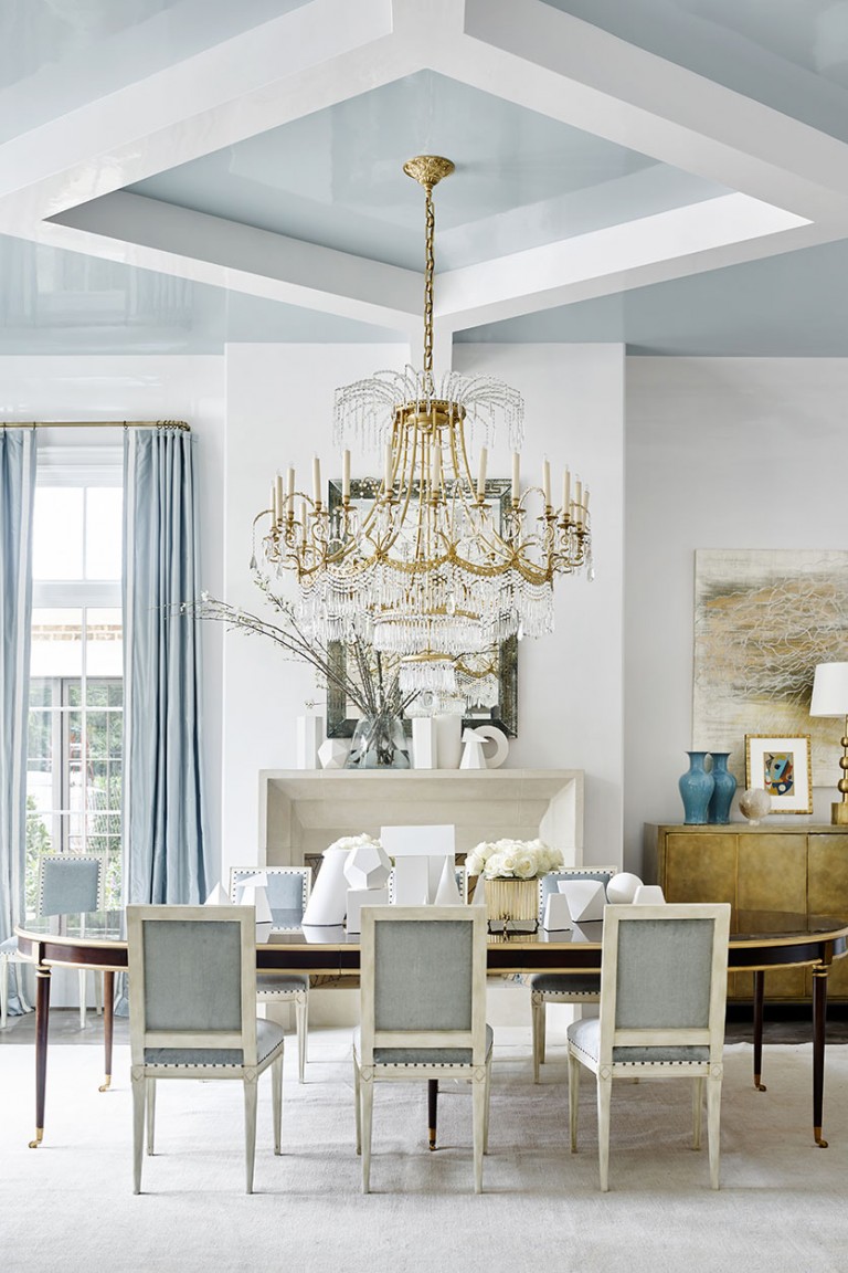 Dining room with a glossy pale blue coffered ceiling, a crystal chandelier and gray upholstered chairs