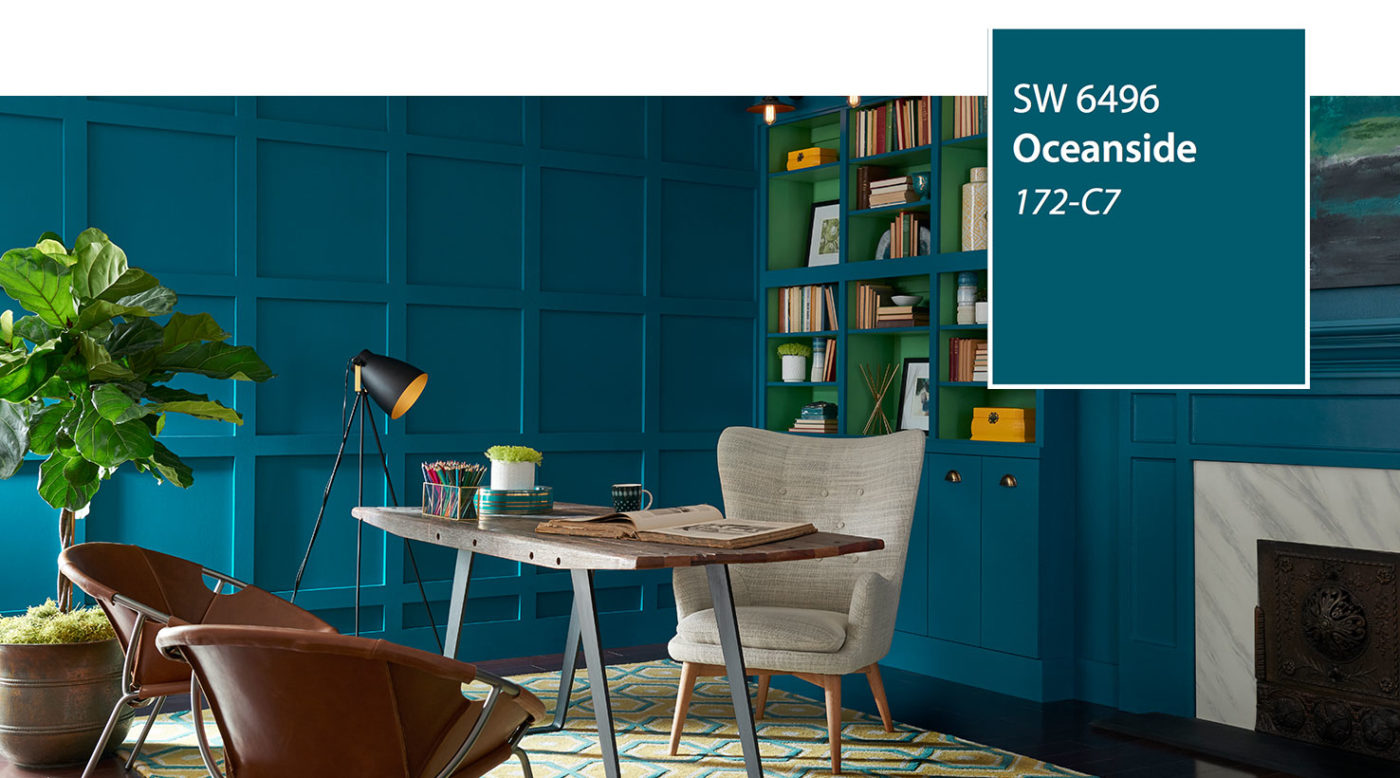 Study with teal paneled walls in Sherwin-Williams Oceanside SW 6496, a wood desk, tripod lamp and leather chairs