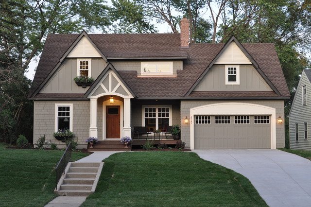Craftsman style house with greige shingle siding, white trim, a stained wood front door and a greige garage door
